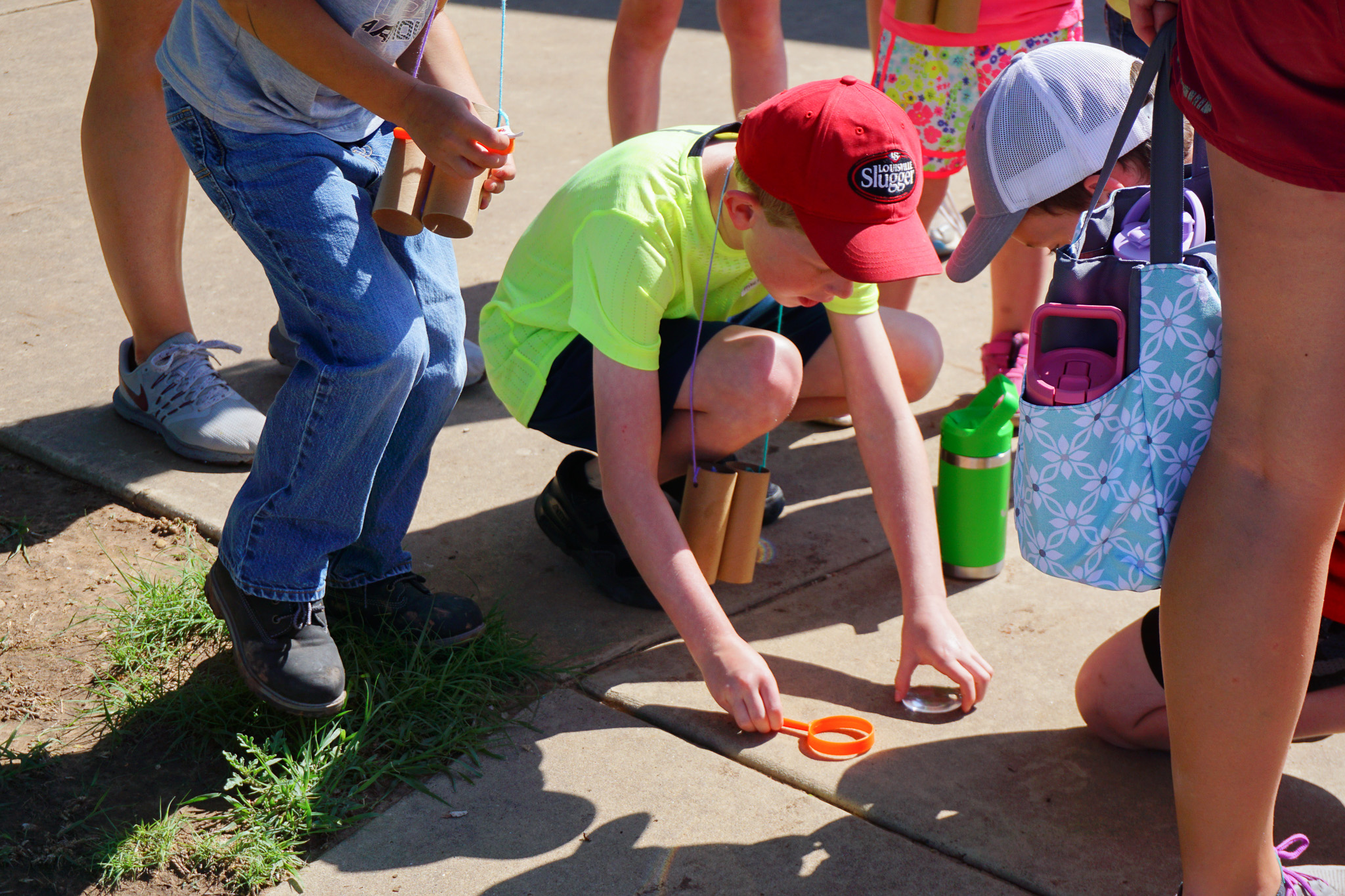Group of children using magnifying glasses to explore. Outdoor science and nature camp at Wildcat Bluff