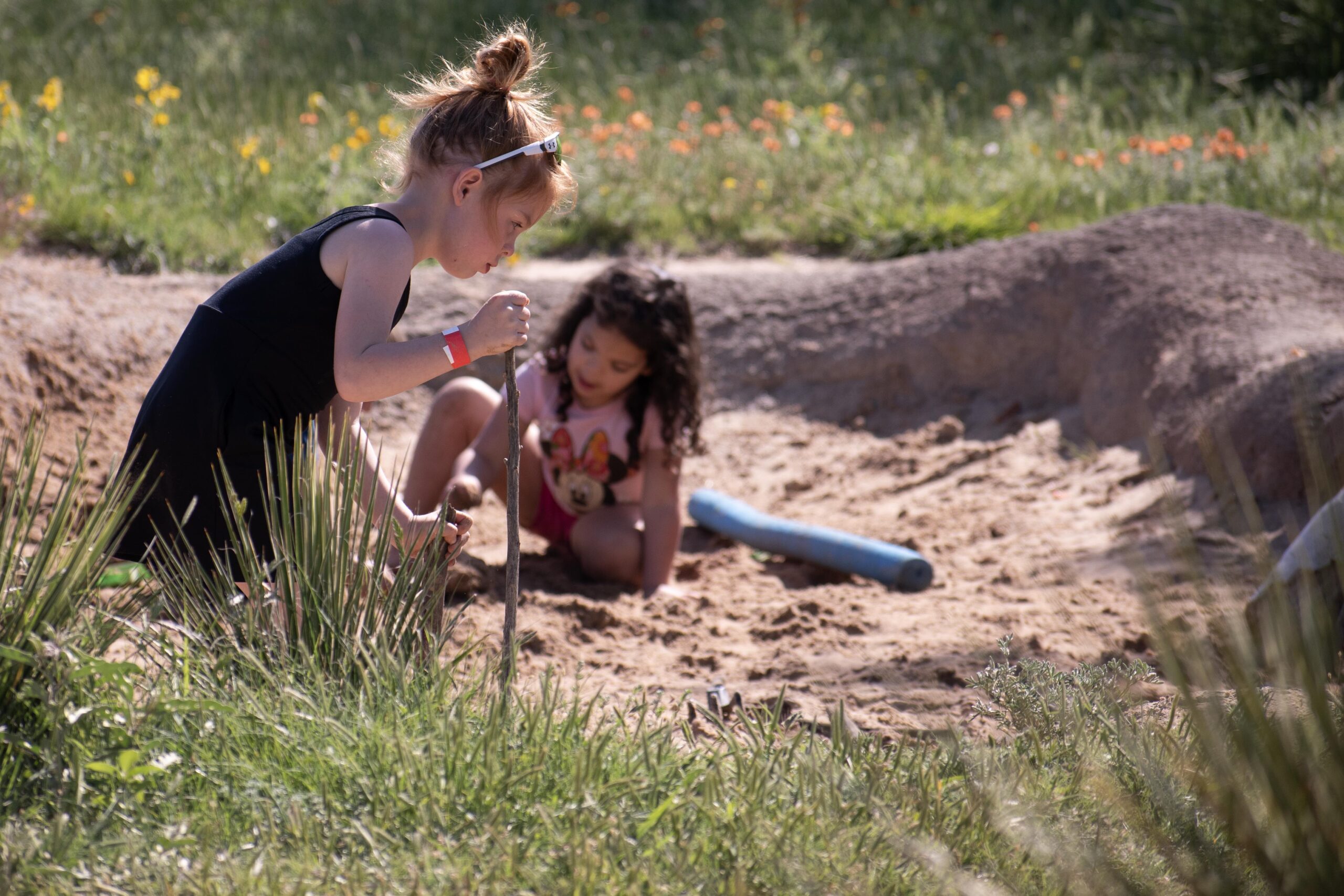 Two girls exploring a sand pit. Outdoor science and nature camp at Wildcat Bluff
