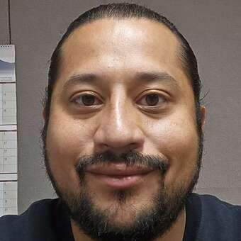 A headshot photo of a man smiling